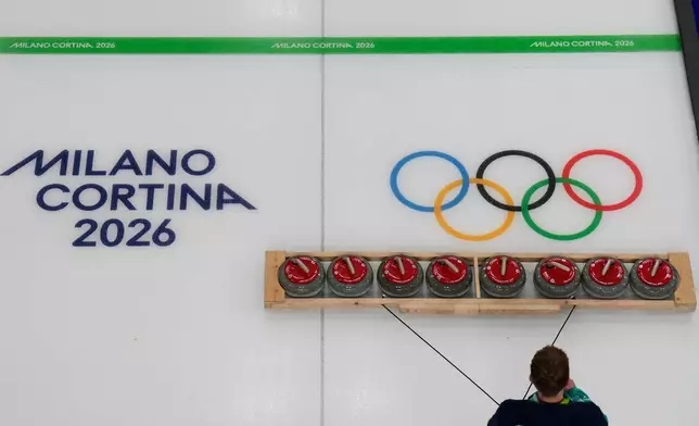 Curling stones are prepared ahead of a men's curling round robin session at the 2026 Winter Olympics, in Cortina d'Ampezzo, Italy, Wednesday, Feb. 11, 2026. (AP Photo/David J. Phillip)