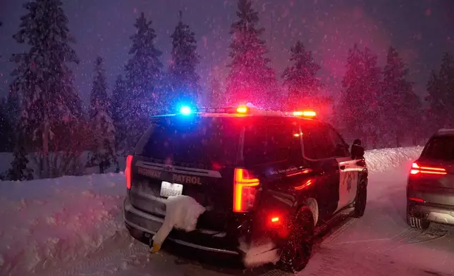 A California Highway Patrol vehicle is parked along a road during a snow storm Wednesday, Feb. 18, 2026, in Placer County, Calif. (AP Photo/Godofredo A. Vásquez)