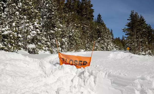A closed sign is partially buried at the entrance to the Castle Peak trailhead in Soda Springs, Calif., Friday, Feb. 20, 2026. (Stephen Lam/San Francisco Chronicle via AP)