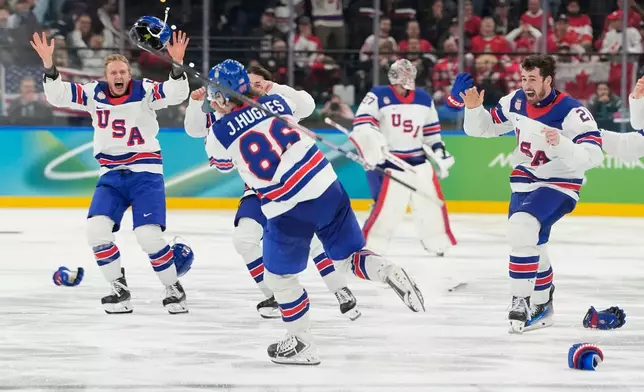 United States players celebrate after scoring during a men's ice hockey gold medal game between Canada and the United States at the 2026 Winter Olympics, in Milan, Italy, Sunday, Feb. 22, 2026. (AP Photo/Hassan Ammar)