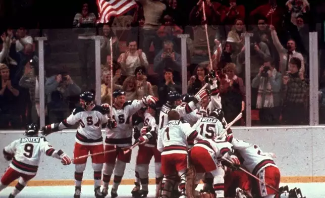 FILE - United States' hockey team pounces on goalie Jim Craig after a 4-3 victory against the Soviet Union in a medal round match at the the 1980 Winter Olympics in Lake Placid, N.Y., Feb. 22, 1980. (AP Photo/File)