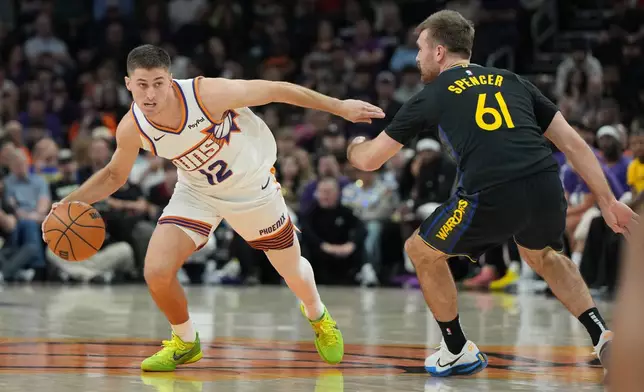 Phoenix Suns guard Collin Gillespie drives past Golden State Warriors guard Pat Spencer (61) during the first half of an NBA basketball game, Thursday, Feb. 5, 2026, in Phoenix. (AP Photo/Rick Scuteri)