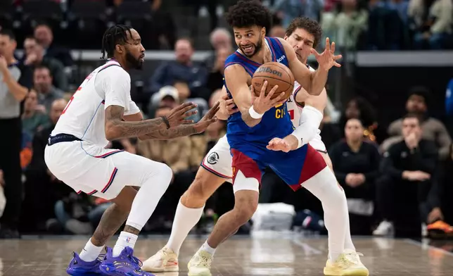 Los Angeles Clippers forward Derrick Jones Jr., left, and center Brook Lopez, back right, defend against Denver Nuggets guard Jamal Murray, front right, during the first half of an NBA basketball game Thursday, Feb. 19, 2026, in Inglewood, Calif. (AP Photo/Kyusung Gong)