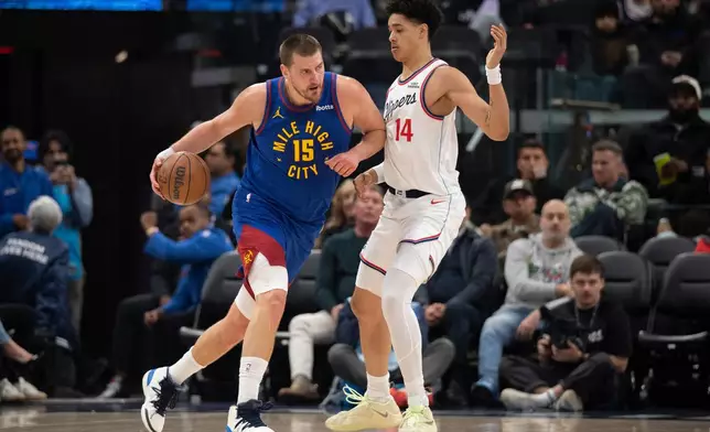 Denver Nuggets center Nikola Jokic (15) drives to the basket as Los Angeles Clippers center Yanic Konan Niederhauser (14) defends during the first half of an NBA basketball game Thursday, Feb. 19, 2026, in Inglewood, Calif. (AP Photo/Kyusung Gong)