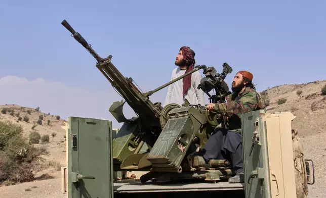 Taliban fighters look up while manning an armed pickup truck at the Afghan side of the Ghulam Khan crossing with Pakistan in Khost province, Afghanistan, Friday, Feb. 27, 2026. (AP Photo/Saifullah Zahir)