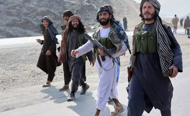 Afghan Taliban soldiers walk along the main road on the Afghan side of the Torkham border crossing with Pakistan in Torkham, Afghanistan, Friday, Feb. 27, 2026. (AP Photo/Wahidullah Kakar)