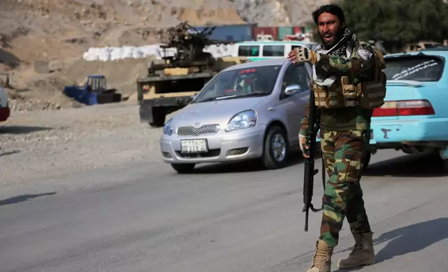 An Afghan Taliban soldier gives instructions to drivers on the Afghan side of the Torkham border crossing with Pakistan in Torkham, Afghanistan, Friday, Feb. 27, 2026. (AP Photo/Wahidullah Kakar)