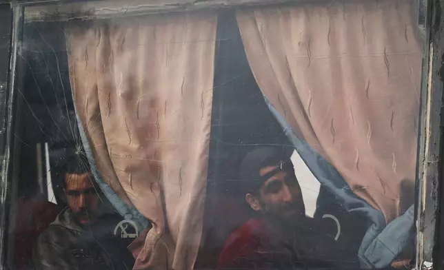 Syrian government prisoners look out from a bus after their release in a prisoner exchange between Syrian government forces and Druze militiamen in Sweida province, Syria, Thursday, Feb. 26, 2026. (AP Photo/Ghaith Alsayed)