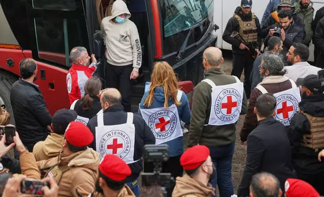 Red Cross staff look on as Syrian government prisoners arrive by bus after their release in a prisoner exchange between Syrian government forces and Druze militiamen in Sweida province, Syria, Thursday, Feb. 26, 2026. (AP Photo/Ghaith Alsayed)