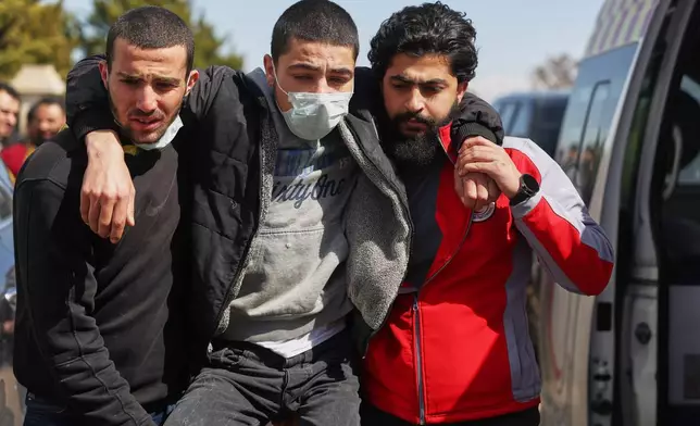 A Syrian government combatant is assisted by Red Crescent paramedics after being released in a prisoner exchange between Syrian government forces and Druze militiamen in Sweida province, Syria, Thursday, Feb. 26, 2026. (AP Photo/Ghaith Alsayed)