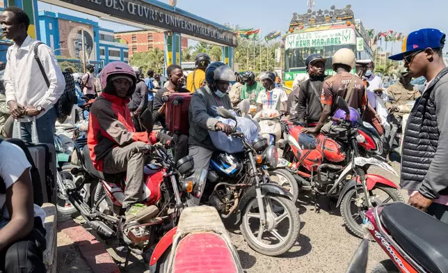A student transports his belongings on a motorcycle taxi as he leaves the Cheikh Anta Diop University, which is being evacuated following the death of second year student Abdoulaye Ba, in Dakar Tuesday, Feb. 10, 2026. (AP Photo/Sylvain Cherkaoui)
