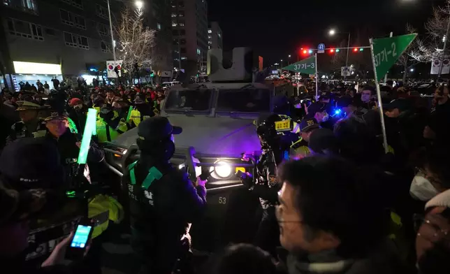 FILE - Military vehicle is escorted by police officers as people try to block outside of the National Assembly in Seoul, South Korea, Dec. 4, 2024. (AP Photo/Lee Jin-man, File)