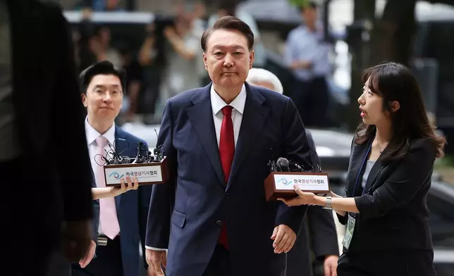 FILE - Former South Korean President Yoon Suk Yeol, center, arrives at a court to attend a hearing to review his arrest warrant requested by special prosecutors in Seoul, South Korea, July 9, 2025. (Kim Hong-Ji/Pool Photo via AP, File)