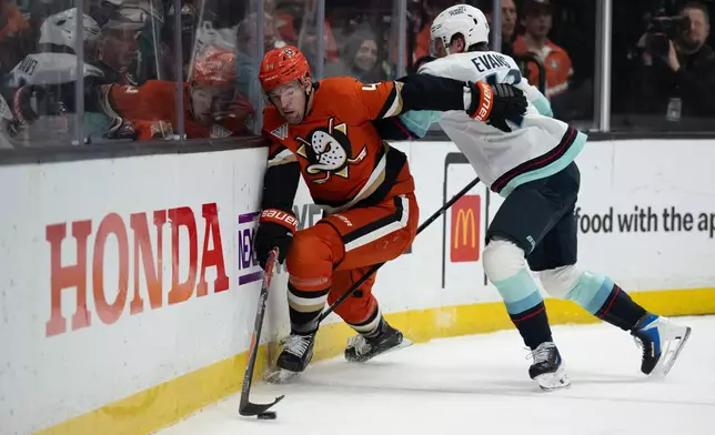 Anaheim Ducks left wing Ross Johnston (44) controls the puck away from Seattle Kraken defenseman Ryker Evans (41) during the first period of an NHL hockey game, Tuesday, Feb. 3, 2026, in Anaheim, Calif. (AP Photo/Kyusung Gong)