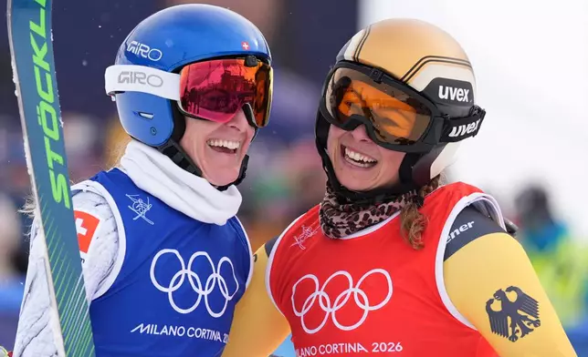 Silver medalist Switzerland's Fanny Smith (3), left, and gold medalist Germany's Daniela Maier (1) embrace after the women's ski cross finals at the 2026 Winter Olympics, in Livigno, Italy, Friday, Feb. 20, 2026. (AP Photo/Rebecca Blackwell)