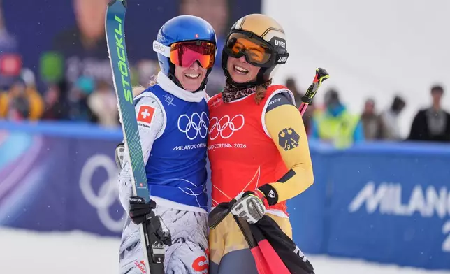 Switzerland's Fanny Smith (3), left, and Germany's Daniela Maier (1) embrace after the women's ski cross finals at the 2026 Winter Olympics, in Livigno, Italy, Friday, Feb. 20, 2026. (AP Photo/Rebecca Blackwell)