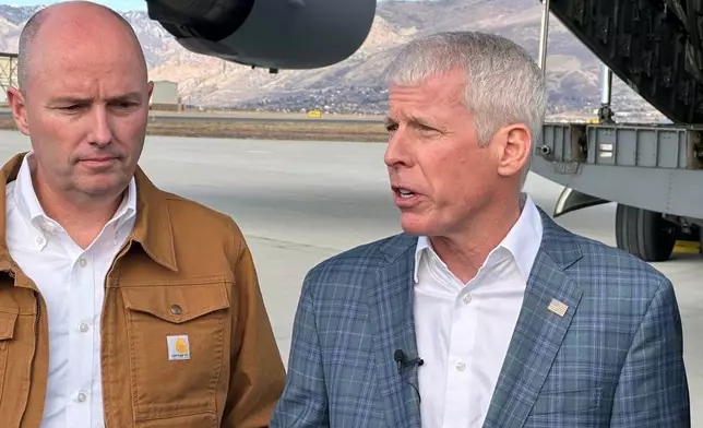Energy Secretary Chris Wright, right, speaks as Utah Gov. Spencer Cox listens, following a news conference at Hill Air Force Base, Utah. Wright and other officials were onboard as a Valar Atomics microreactor, without nuclear fuel, was transported from March Air Reserve Base in California to Hill Air Force Base. Cox met the plane in Utah. (AP Photo/Matthew Daly)