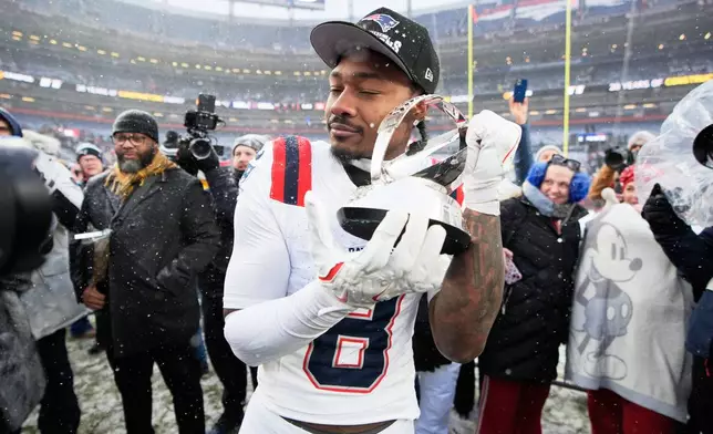 New England Patriots wide receiver Stefon Diggs celebrates with the trophy after the AFC Championship NFL football game between the Denver Broncos and the New England Patriots, Sunday, Jan. 25, 2026, in Denver. (AP Photo/John Locher)