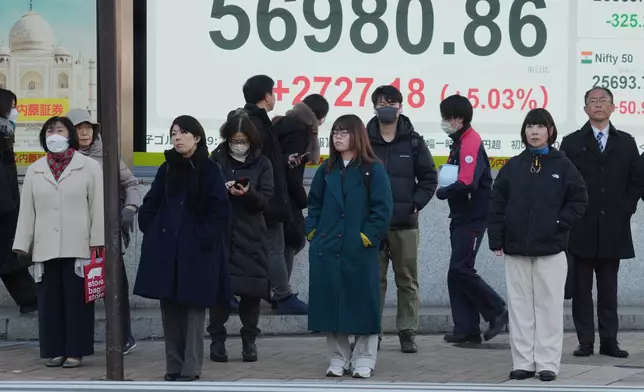 People stand in front of an electronic stock board showing Japan's Nikkei index at a securities firm, Monday, Feb. 9, 2026, in Tokyo. (AP Photo/Eugene Hoshiko)