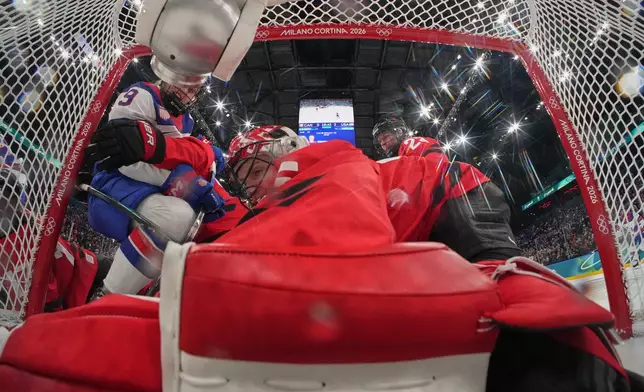 United States' Kirsten Simms, left, scores her side's third goal during a preliminary round match of women's ice hockey between Canada and the United States at the 2026 Winter Olympics, in Milan, Italy, Tuesday, Feb. 10, 2026. (Mike Segar/Pool Photo via AP)
