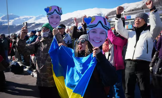 Attendees cheer for Ukraine's Kateryna Kotsar during women's freestyle skiing slopestyle qualifications at the 2026 Winter Olympics, in Livigno, Italy, Saturday, Feb. 7, 2026. (AP Photo/Gregory Bull)
