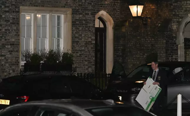 A person leaves the home of Peter Mandelson in north west London, Friday, Feb. 6, 2026 as British police are searching two properties linked to ex-ambassador Peter Mandelson as part of probe into potential misconduct stemming from his ties to the late Jeffrey Epstein.(AP Photo/Thomas Krych)