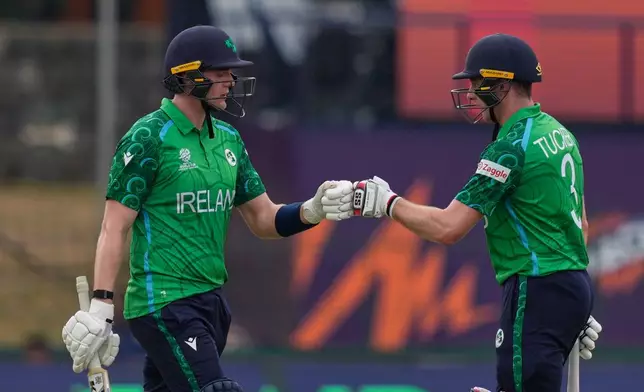 Ireland's Gareth Delany, left, Lorcan Tucker, right, encourage each other as they bat during the T20 World Cup cricket match between Ireland and Oman in Colombo, Sri Lanka, Saturday, Feb. 14, 2026. (AP Photo/Eranga Jayawardena)