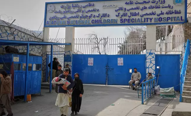 An Afghan couple carrying their child leave the Ataturk National Children's Hospital, in Kabul, Afghanistan, Sunday, Feb. 15, 2026. (AP Photo/Siddiqullah Alizai)