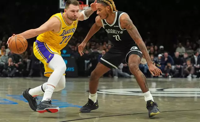 Brooklyn Nets' Noah Clowney, right, defends Los Angeles Lakers' Luka Dončić (77) during the first half of an NBA basketball game Tuesday, Feb. 3, 2026, in New York. (AP Photo/Frank Franklin II)