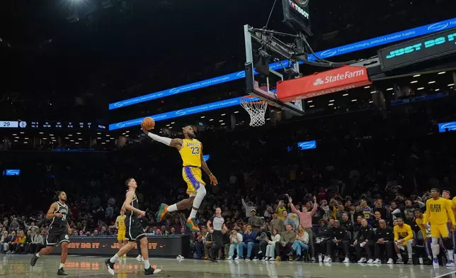 Los Angeles Lakers' LeBron James (23) dunks the ball in front of Brooklyn Nets' Egor Dëmin and Cam Thomas (24) during the first half of an NBA basketball game Tuesday, Feb. 3, 2026, in New York. (AP Photo/Frank Franklin II)