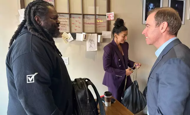 Luke Bronin, former mayor of Hartford, Conn., who is challenging Rep. John Larson, D-Conn., in the 2026 election primary, right, speaks with James Jeter, left, at the Semilla Cafe and Studio in Hartford on Jan. 22, 2026. (AP Photo/Susan Haigh)