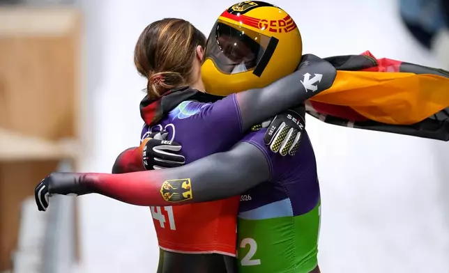 Germany's bronze medalists Christopher Grotheer, right, and Germany's Jacqueline Pfeifer, left, celebrate at the finish during the skeleton mixed team competition at the 2026 Winter Olympics, in Cortina d'Ampezzo, Italy, Sunday, Feb. 15, 2026. (AP Photo/Aijaz Rahi)