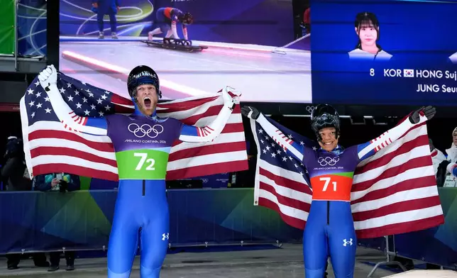 United States' Austin Florian, left, and United States' Mystique Ro celebrate at the finish during the skeleton mixed team competition at the 2026 Winter Olympics, in Cortina d'Ampezzo, Italy, Sunday, Feb. 15, 2026. (AP Photo/Alessandra Tarantino)