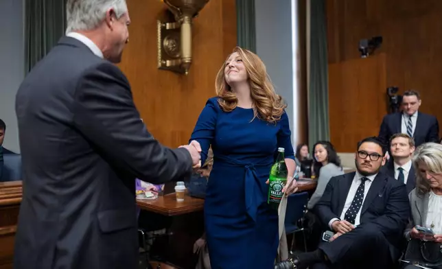 Wellness influencer and entrepreneur Dr. Casey Means is welcomed by Sen. Roger Marshall, R-Kan., left, as she appears before the Senate health committee to seek approval to be U.S. surgeon general, at the Capitol in Washington, Wednesday, Feb. 25, 2026. (AP Photo/J. Scott Applewhite)