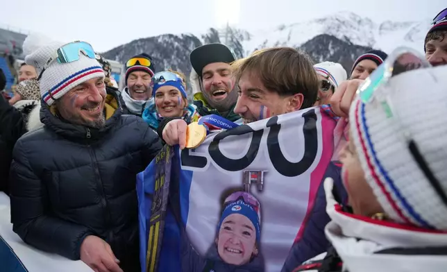Fans of Lou Jeanmonnot, of France, hold a medal after the women's 4x6-kilometer relay biathlon race at the 2026 Winter Olympics in Anterselva, Italy, Wednesday, Feb. 18, 2026. (AP Photo/Andrew Medichini)