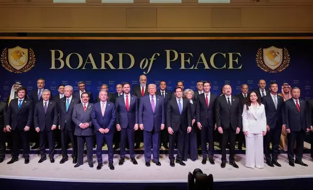 President Donald Trump stands with other World leaders before a Board of Peace meeting at the U.S. Institute of Peace, Thursday, Feb. 19, 2026, in Washington. (AP Photo/Mark Schiefelbein)