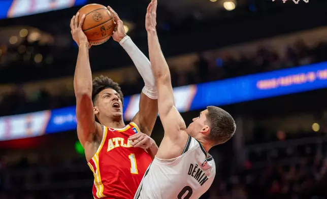 Atlanta Hawks forward Jalen Johnson (1) attempts a basket against Brooklyn Nets guard Egor Dëmin (8) during the first half of an NBA basketball game, Sunday, Feb. 22, 2026, in Atlanta. (AP Photo/Erik Rank)