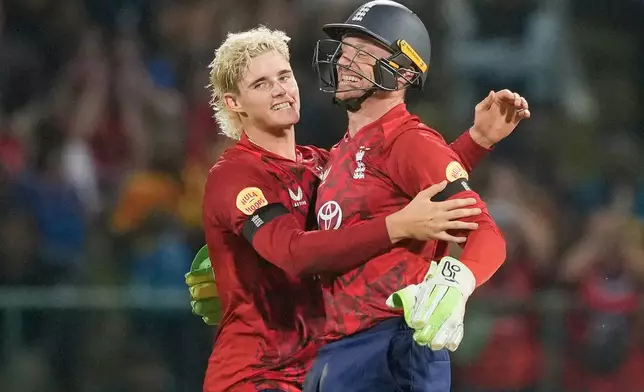 England's Jacob Bethell, left, and Jos Buttler celebrates the wicket of Sri Lanka's Dunith Wellalage during the third T20 cricket match between England and Sri Lanka in Pallekele, Sri Lanka, Tuesday, Feb, 3. 2026. (AP Photo/Eranga Jayawardena)