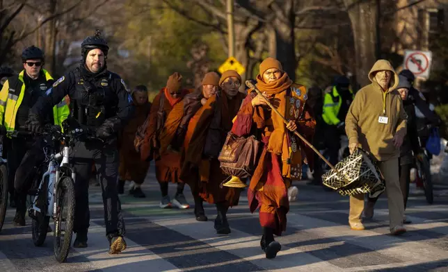 Buddhist monks who are participating in a Walk For Peace walk through a neighborhood on Tuesday, Feb. 10, 2026, in Washington. (AP Photo/Mark Schiefelbein)