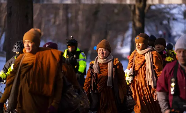 Buddhist monks who are participating in a Walk For Peace walk through a neighborhood on Tuesday, Feb. 10, 2026, in Washington. (AP Photo/Mark Schiefelbein)