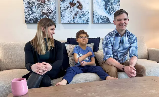 Logan Coyle, nine years old, center, answers questions during an interview with his parents Rebecca Coyle, left, and Logan Coyle, Feb. 10, 2026, in New York. (AP Photo/Phil Marcelo)