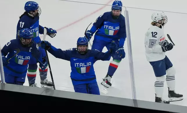 Italy's Matilde Fantin (17) celebrates scoring a goal in the third period with Italy's Nadia Mattivi (93), Italy's Justine Reyes (11), Italy's Franziska Stocker (18), as France's Estelle Duvin (12) skates away during a preliminary round match of women's ice hockey between Italy and France at the 2026 Winter Olympics, in Milan, Italy, Thursday, Feb. 5, 2026. (AP Photo/Carolyn Kaster)