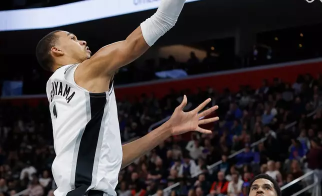 San Antonio Spurs forward Victor Wembanyama, left, goes to the basket against the Detroit Pistons during the first half of an NBA basketball game Monday, Feb. 23, 2026, in Detroit. (AP Photo/Duane Burleson)