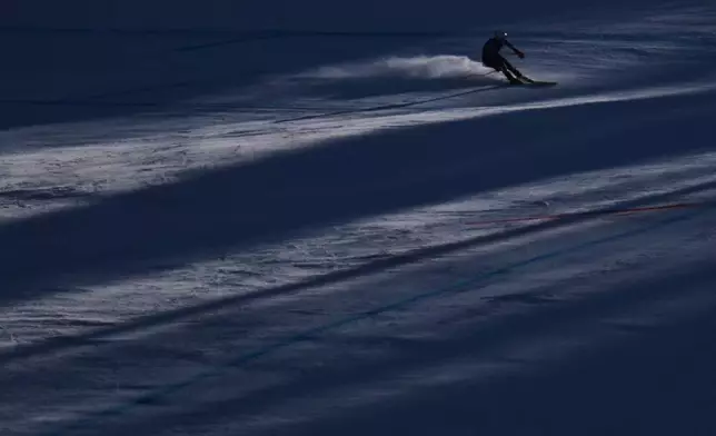 Finland's Elian Lehto is silhouetted as he speeds down the course of an alpine ski men's downhill portion of a team combined race, at the 2026 Winter Olympics, in Bormio, Italy, Monday, Feb. 9, 2026. (AP Photo/Rebecca Blackwell)