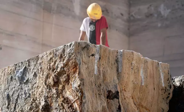 Workers use a jackhammer to break a block of travertine at the Degemar Quarry near Tivoli, Italy, 35 kilometers east of Rome, on Friday, Feb. 13, 2026, where 17th-century Baroque architect Gian Lorenzo Bernini selected travertine for the colonnade of St. Peter's Square. (AP Photo/Gregorio Borgia)