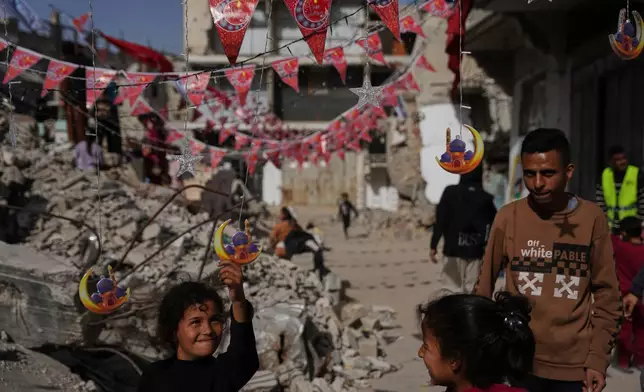 Palestinians hang decorations beside the rubble of destroyed homes as they prepare for the holy month of Ramadan in Khan Younis, southern Gaza Strip, Sunday, Feb. 15, 2026. (AP Photo/Abdel Kareem Hana)