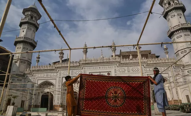 Workers clean carpet at the historic Mahabat Khan mosque in preparation for the upcoming Muslim fasting month of Ramadan, in Peshawar, Pakistan, Monday, Feb. 16, 2026. (AP Photo/Muhammad Sajjad)