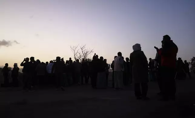 People gather to sight the Ramadan crescent moon marking the beginning of the holy month of Ramadan at the foothills of Mount Qasioun near the Tomb of the Unknown Soldier in Damascus, Tuesday, Feb. 17, 2026. (AP Photo/Ghaith Alsayed)