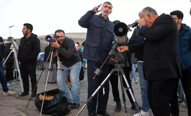 People gather to sight the Ramadan crescent moon marking the beginning of the holy month of Ramadan at the foothills of Mount Qasioun near the Tomb of the Unknown Soldier in Damascus, Tuesday, Feb. 17, 2026. (AP Photo/Ghaith Alsayed)
