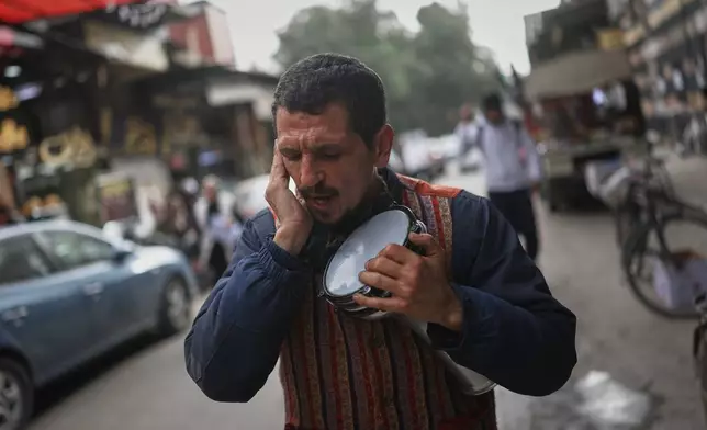 A man sings traditional Ramadan chants as residents prepare for the upcoming Muslim holy month of Ramadan at the Al-Jazmatiya market in Damascus, Tuesday, Feb. 17, 2026. (AP Photo/Ghaith Alsayed)